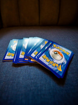 A small collection of Pokémon cards laid out on a blue surface