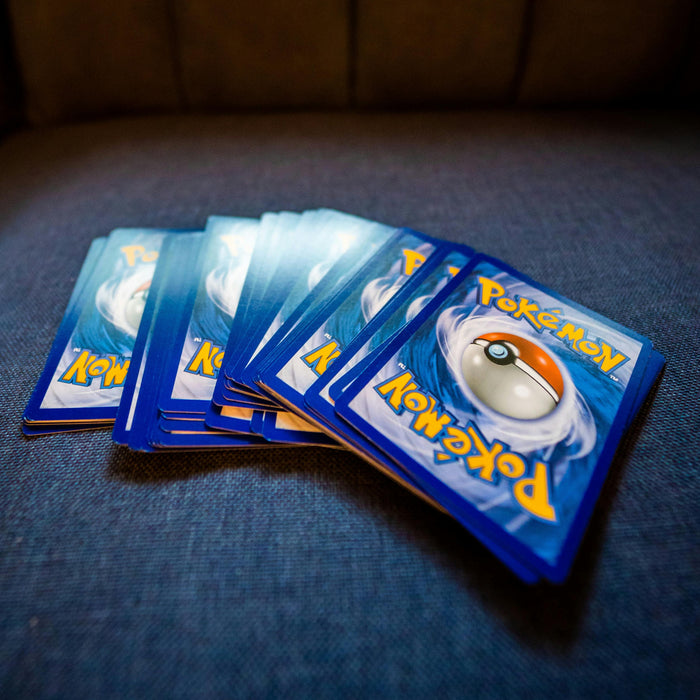 A small collection of Pokémon cards laid out on a blue surface